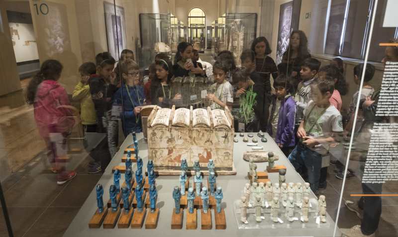 Bambini davanti ad una teca di vetro durante un tour educativo.